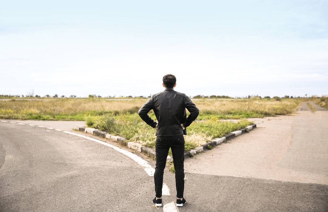 Man standing at a crossroads, symbolizing the decision-making process when choosing a workers’ compensation attorney