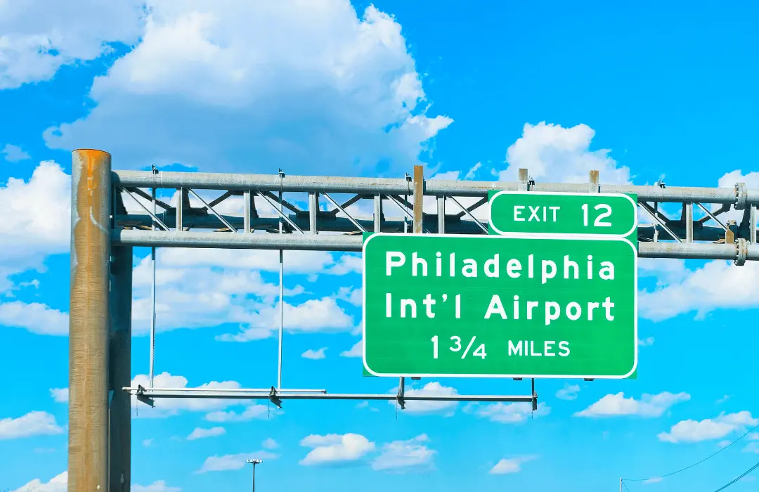 Highway sign directing travelers to Philadelphia International Airport in Philadelphia, Pennsylvania, highlighting a major workplace location for airport workers and workers’ compensation claims.