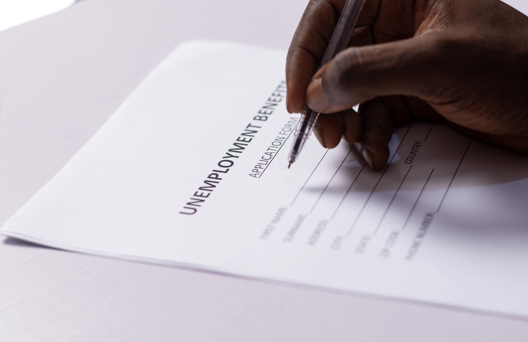 Close-up of a person filling out an unemployment benefits application form, relevant to workers’ compensation claims in Pennsylvania.